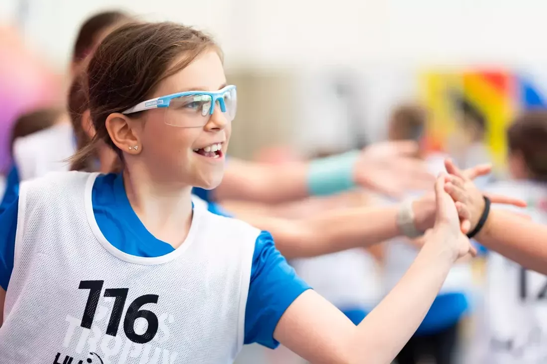 Juniorin klatscht strahlend mit ihrem Team ab